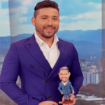 Carlos Nateran sosteniendo una figura y réplica en miniatura hecha a mano por Artesania Rueda