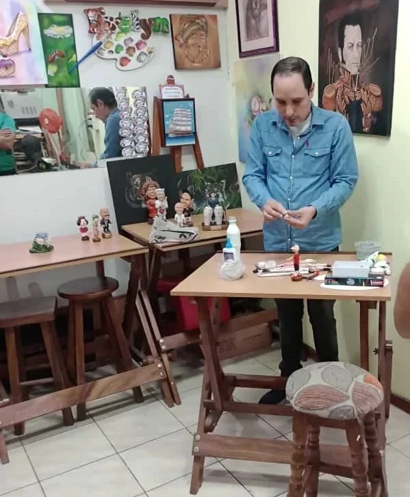 José Rueda trabajando minuciosamente en el modelado y pintura a mano de una figura 3D en su estudio de Artesanía Rueda.