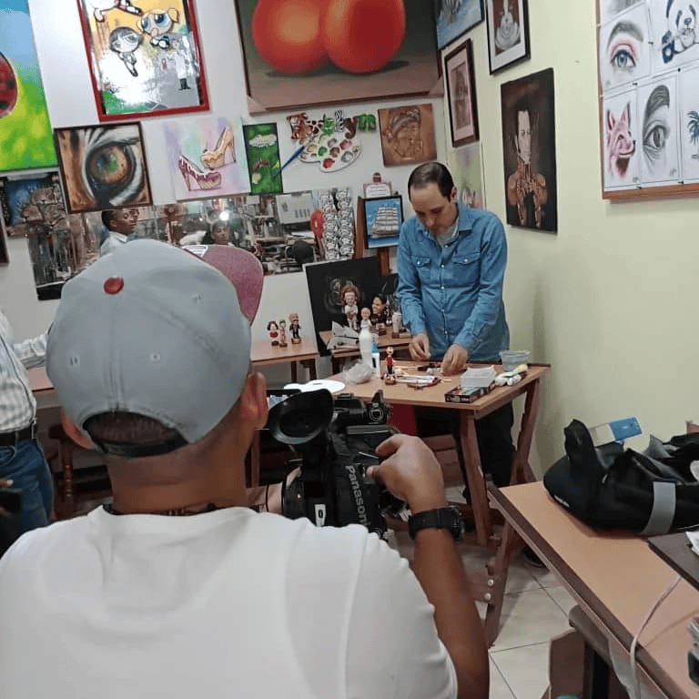 José Rueda, escultor de Artesanía Rueda, tallando una figura personalizada durante una entrevista para televisión.