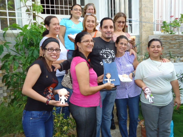 Grupo de personas mostrando diversas esculturas artesanales creadas en el taller de Artesanía Rueda